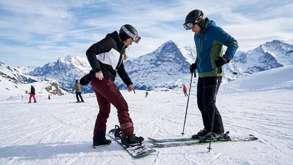 Snowboarder and skier side by side on a snowy mountain slope comparing their pants